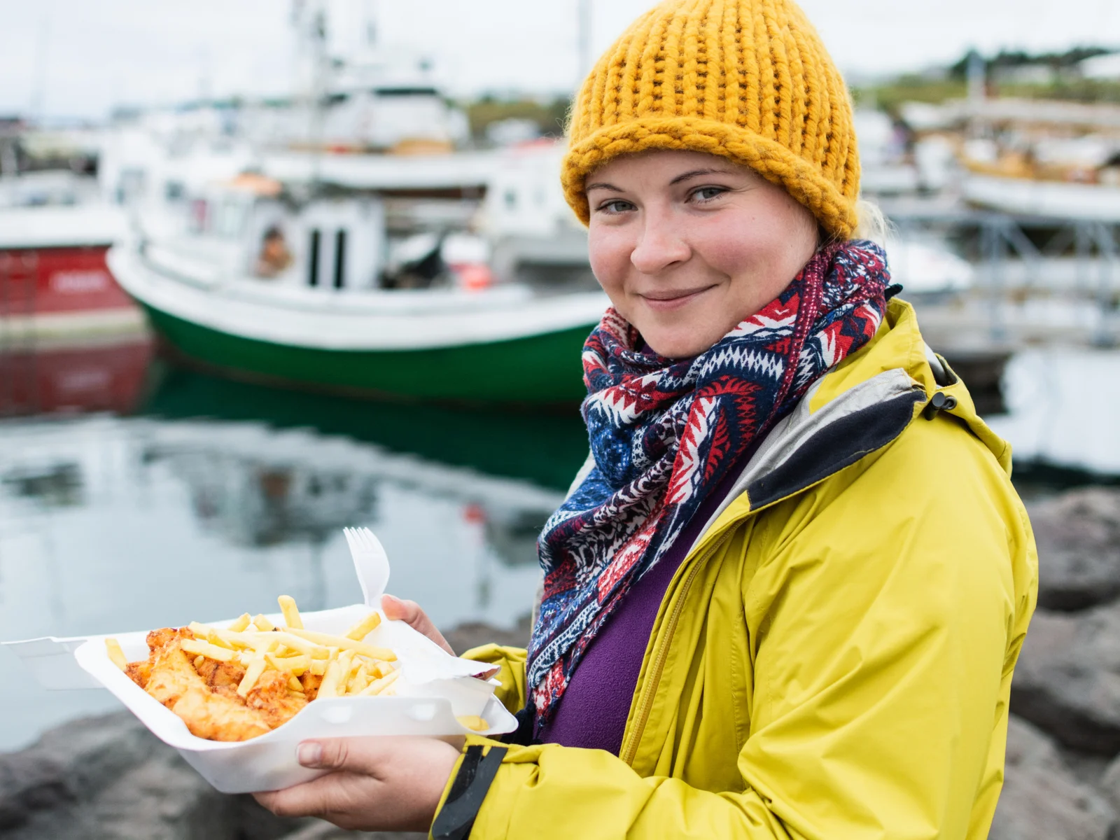 Woman eating a small portion of fish and chips, a popular dish served at Iceland's best restaurants