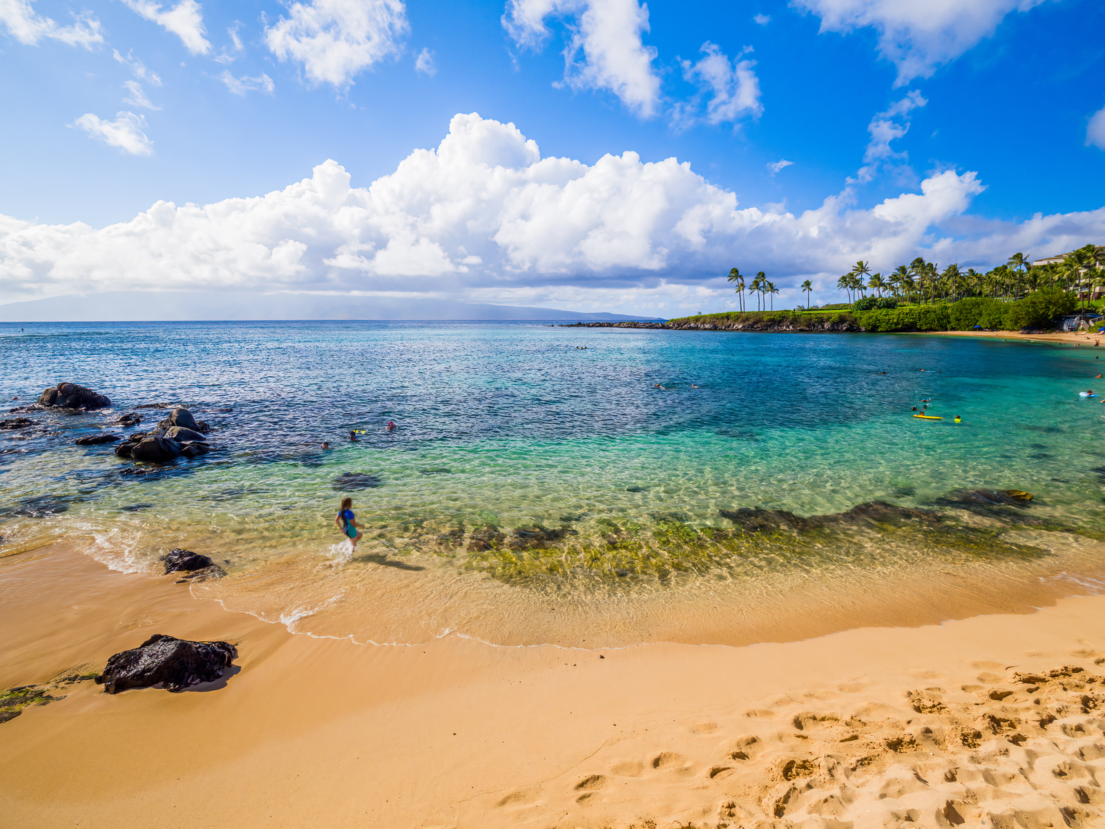 kids swimming at the clear shallow waters of Kapalua Bay on summer, one of the best swimming and best snorkeling spots in Hawaii