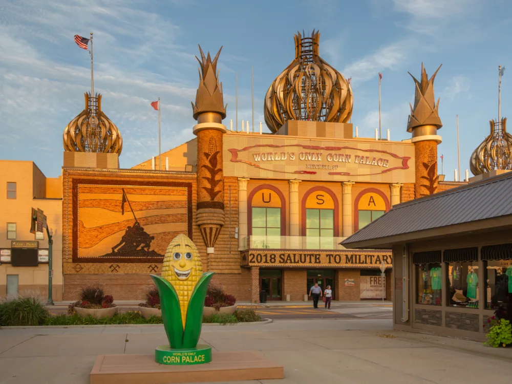 A golden afternoon at one of the best South Dakota tourist attractions, the Corn Palace where a couple is seen walking out of the attraction