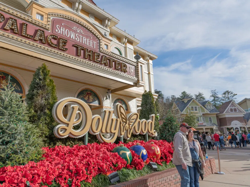 A couple posing for a picture and a crowd in Dollywood, a famous attraction and one of the best things to do in Tennessee