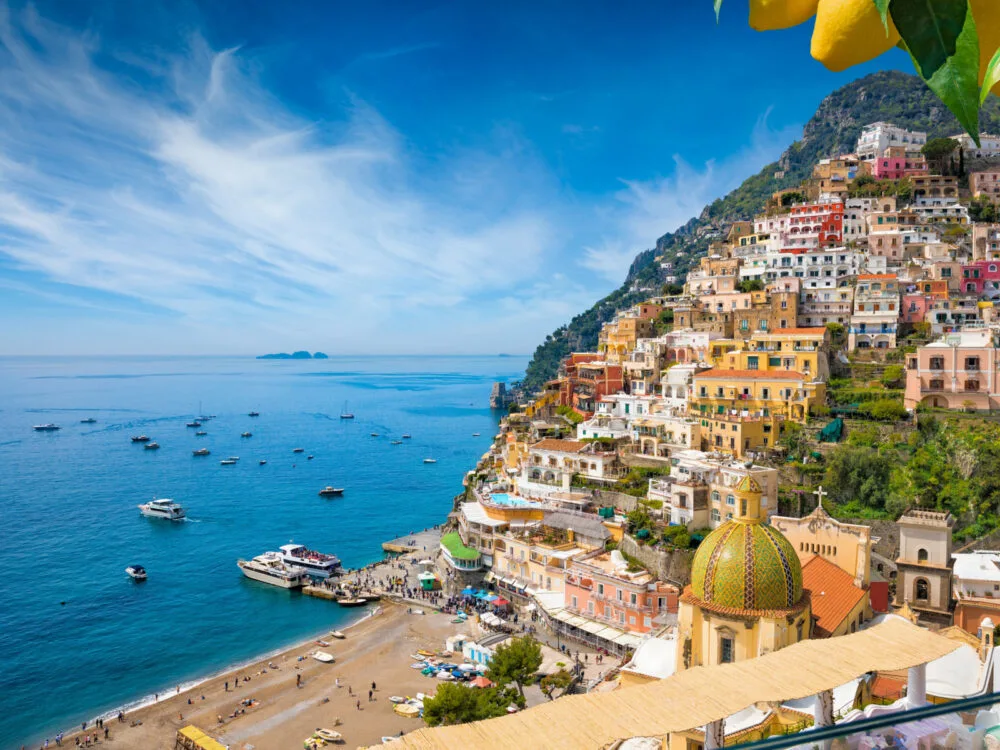 Aerial view of Positano, one of the best places to visit in Italy, with blue skies and blue ocean water