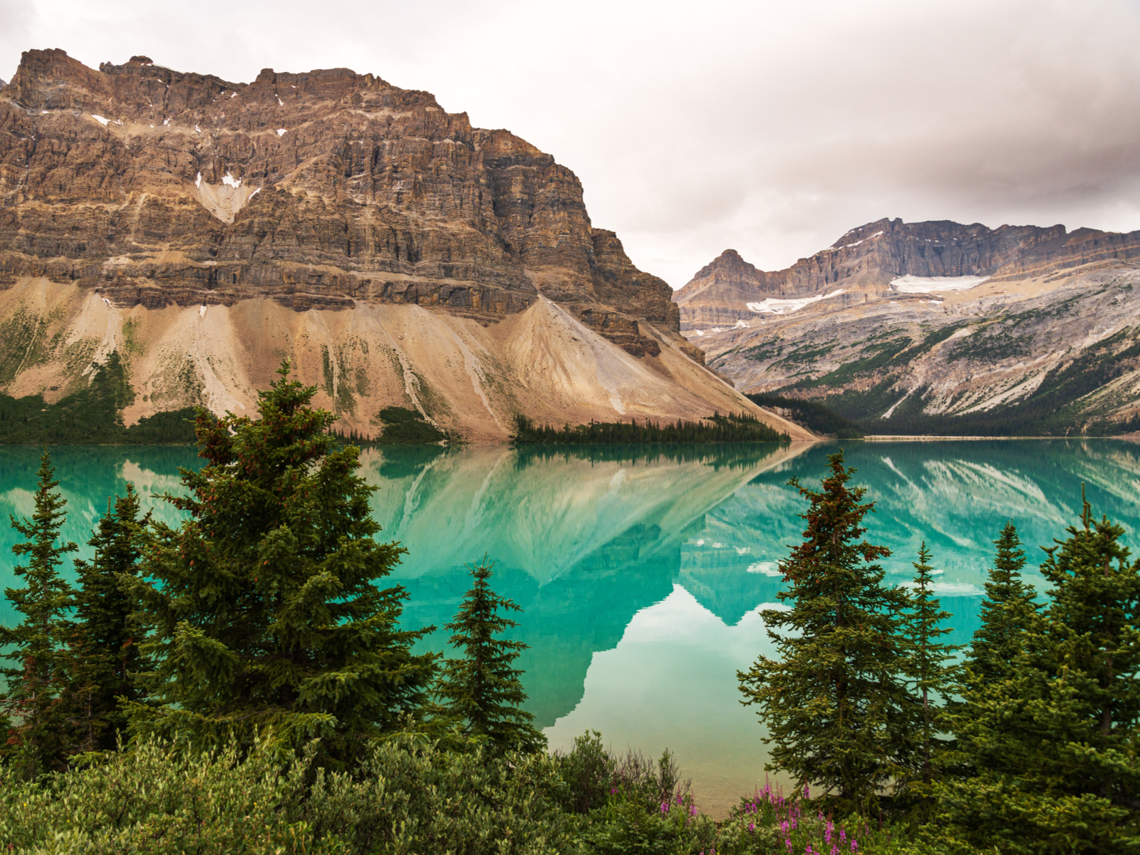 Gorgeous emerald green lake pictured during the best time to visit Glacier National Park