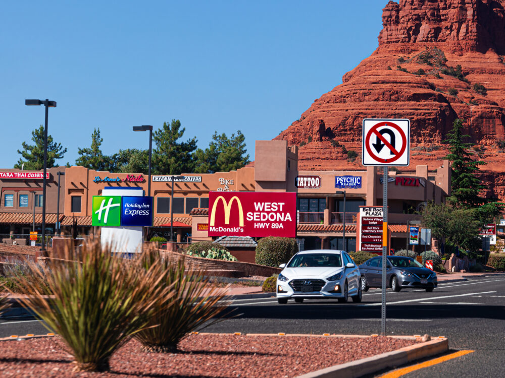 Photo of one of the best places to stay in Sedona Arizona, West Sedona, with a Mcdonalds and a few hotels next to the red rocks