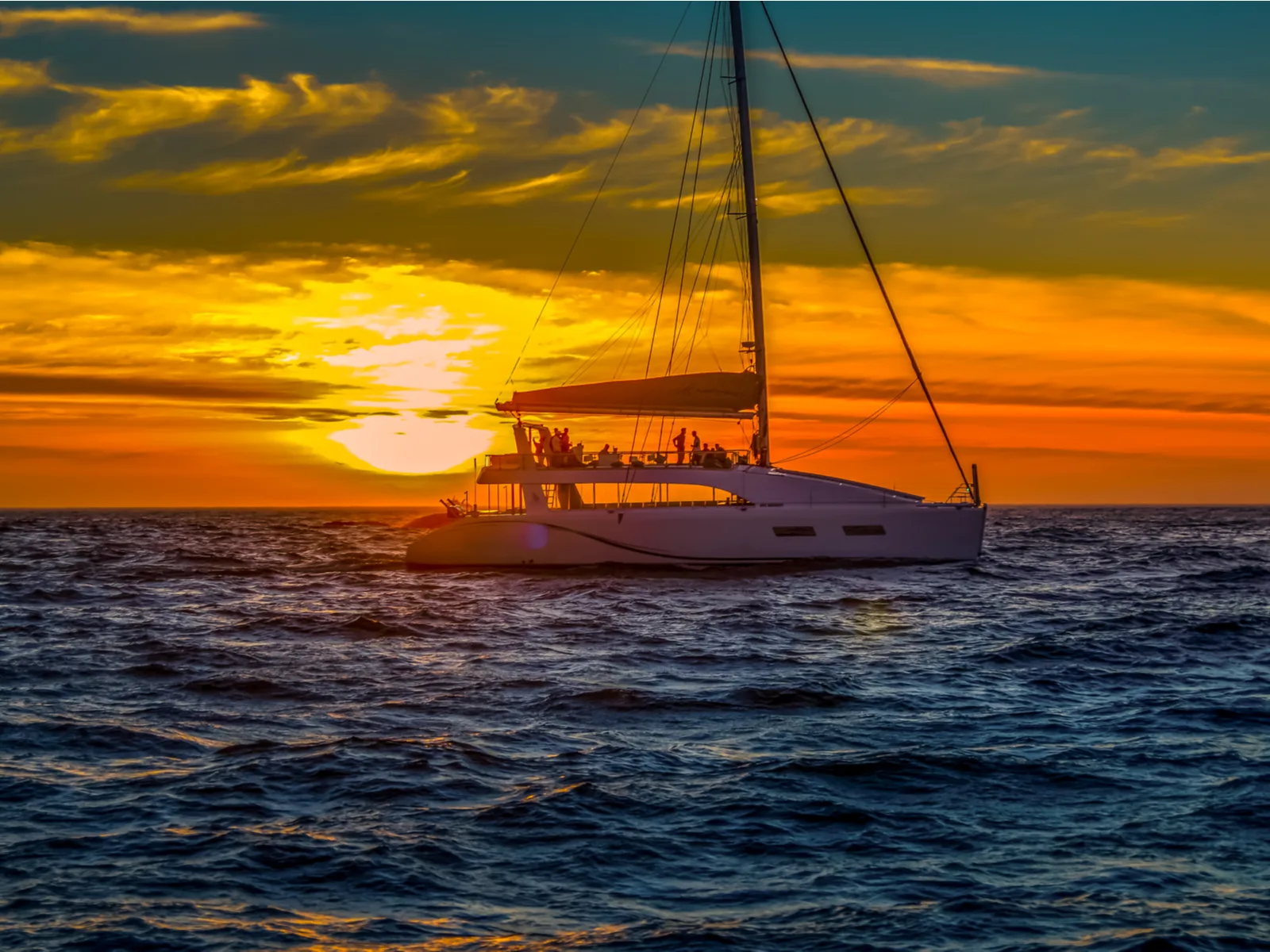 Several people onboard a yacht on a golden Sunset Cruise, one of the best things to do in Costa Rica