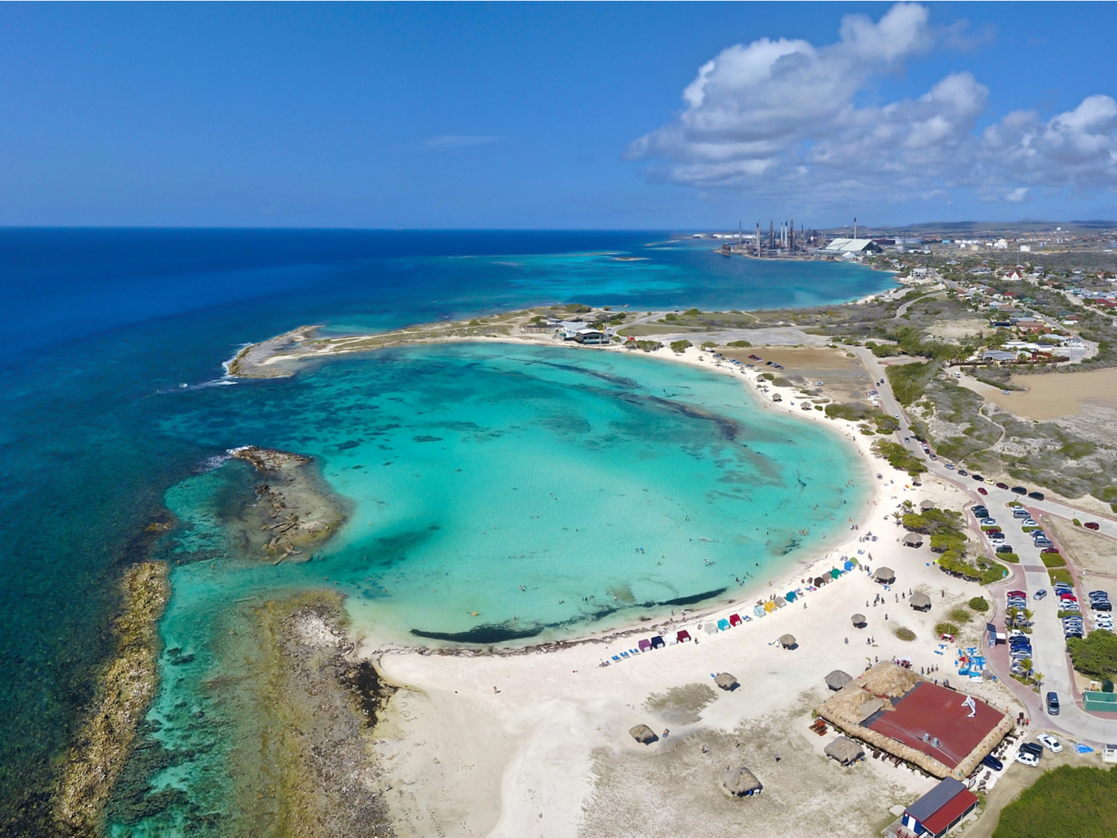 Aerial view of the beautiful curve man-made lagoon with shallow waters on Baby Beach, one of the best beaches in Aruba, and coast on Aruba