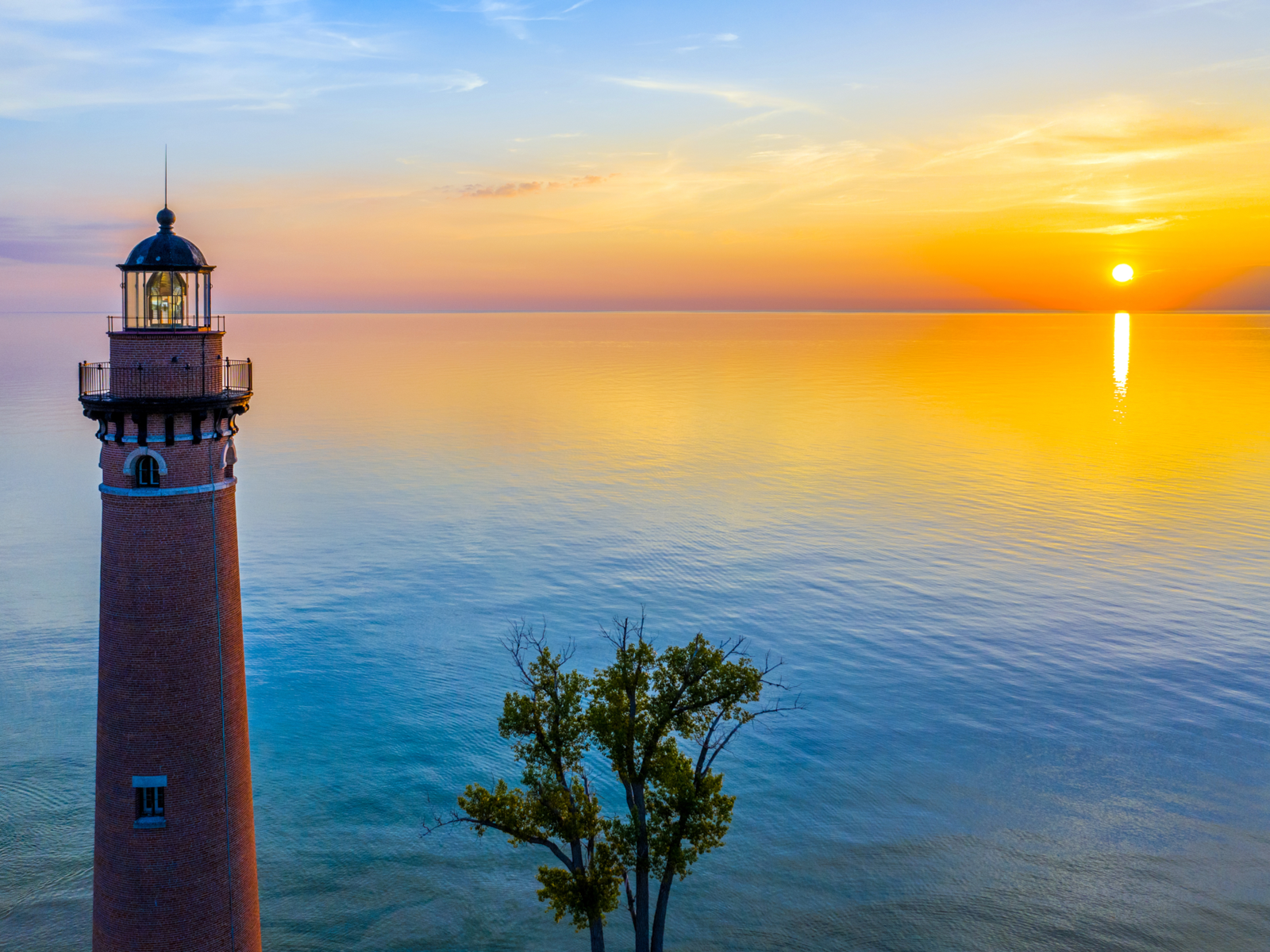 Crimson sunset over Little Sable Point Lighthouse at tranquil Lake Michigan, known as one of the best lakes in the U.S.