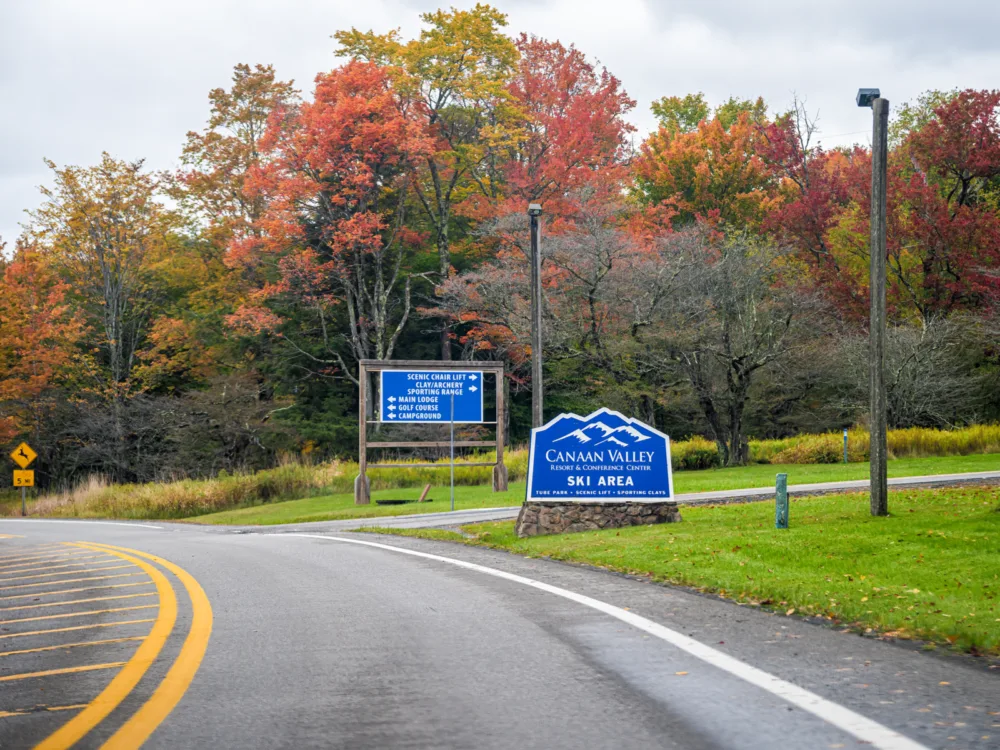 One of the best attractions in West Virginia, Canaan Valley Ski Resort's signage on the roadside with vibrant trees on Autumn