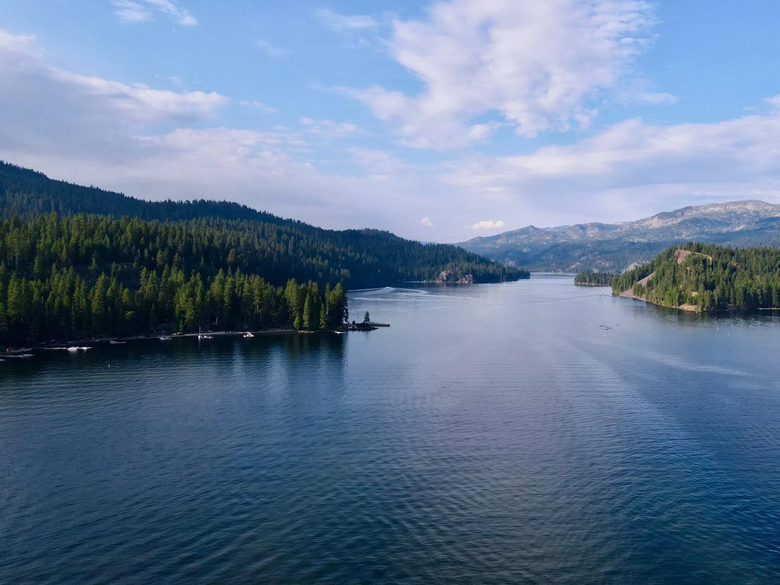 Aerial view of the deep calm water of Payette Lake, one of the best things to see in Idaho, and the think green forest of Ponderosa State Park on the left side