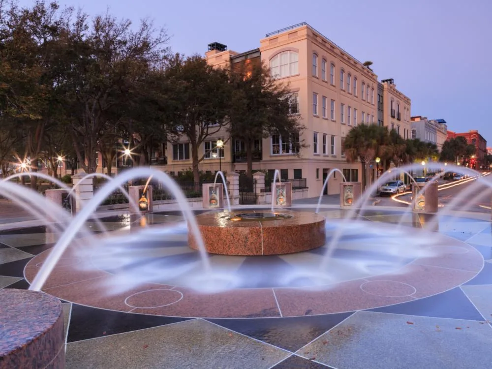 Waterfront fountain pictured during the least busy time to visit Charleston SC with a water fountain spewing onto concrete