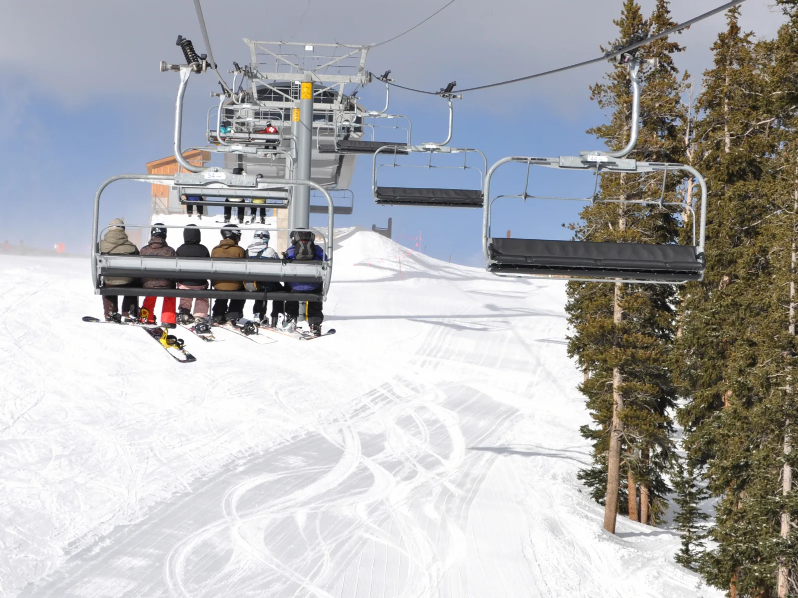 A group of skiers in full gear riding up the chairlift in Keystone Resort, one of the best ski resorts near Denver