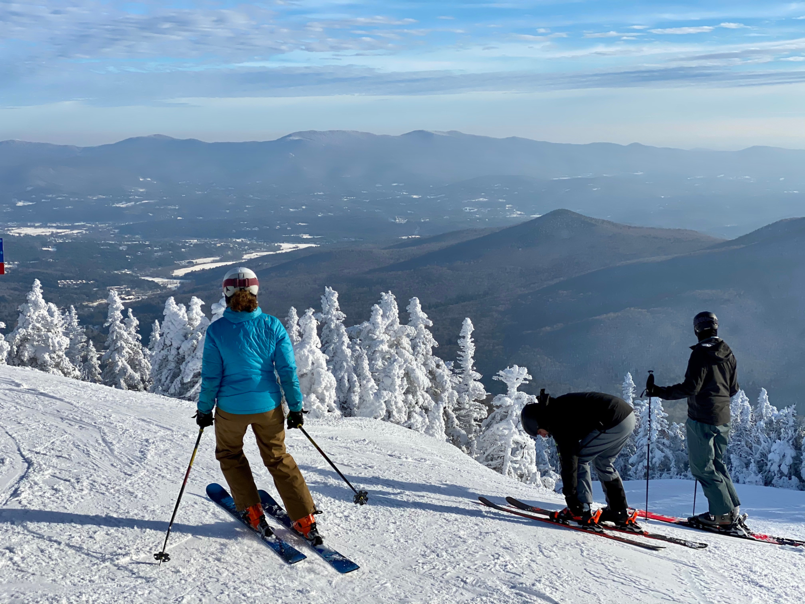 Skiers ready to ski down a mountain at one of the best places to visit in Vermont, Stowe