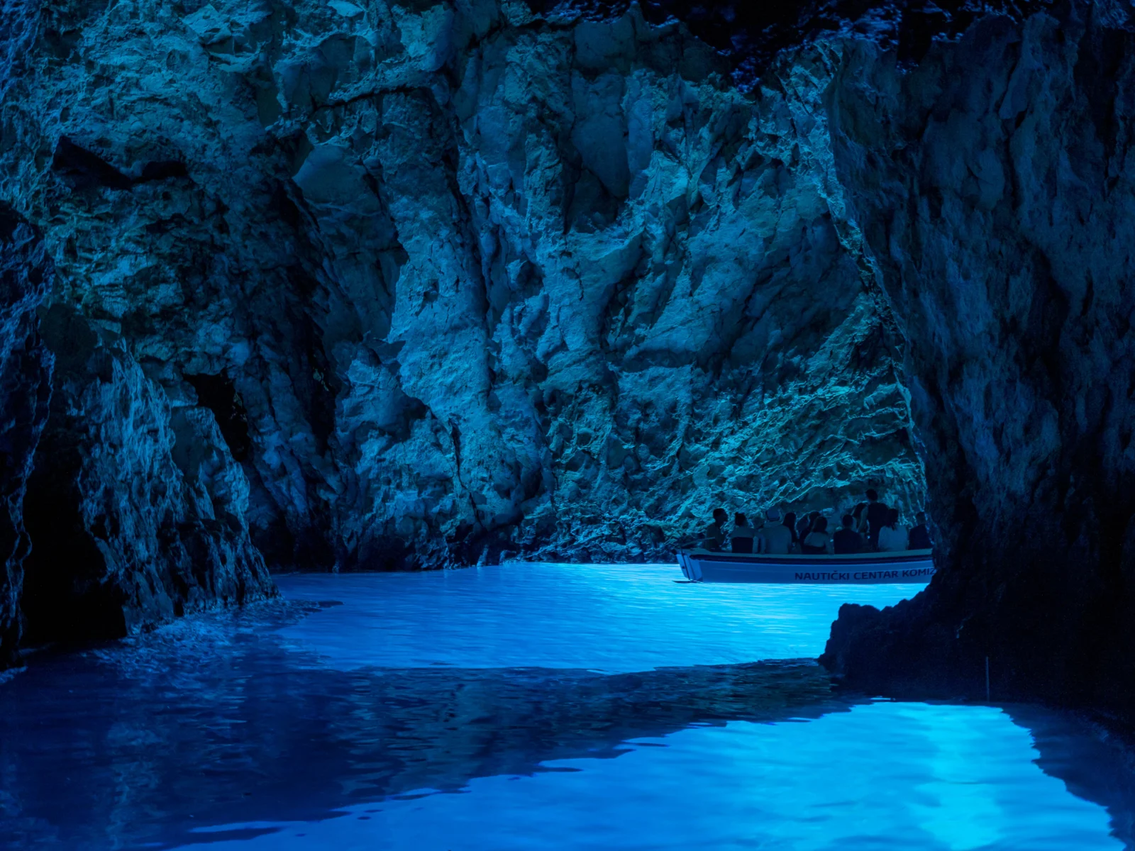 Tourists on a boat over the blue cave in Croatia, one of the best island vacations you can take