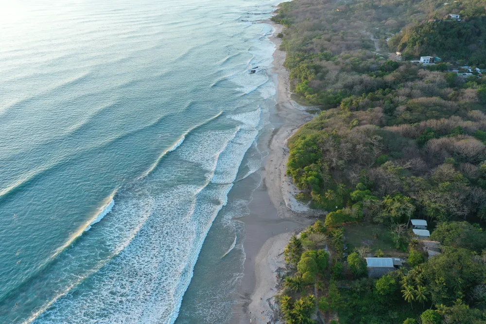 Aerial view of Santa Teresa Beach, one of the best beaches in Costa Rica, with waves crashing around sunrise