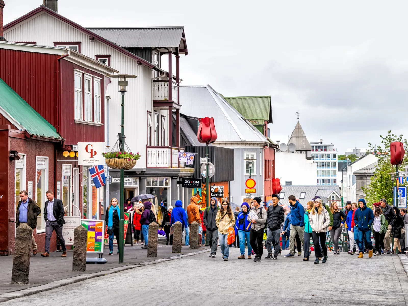 A crowd of tourists walking by one of the best restaurants in Iceland along the street of Reykjavik 