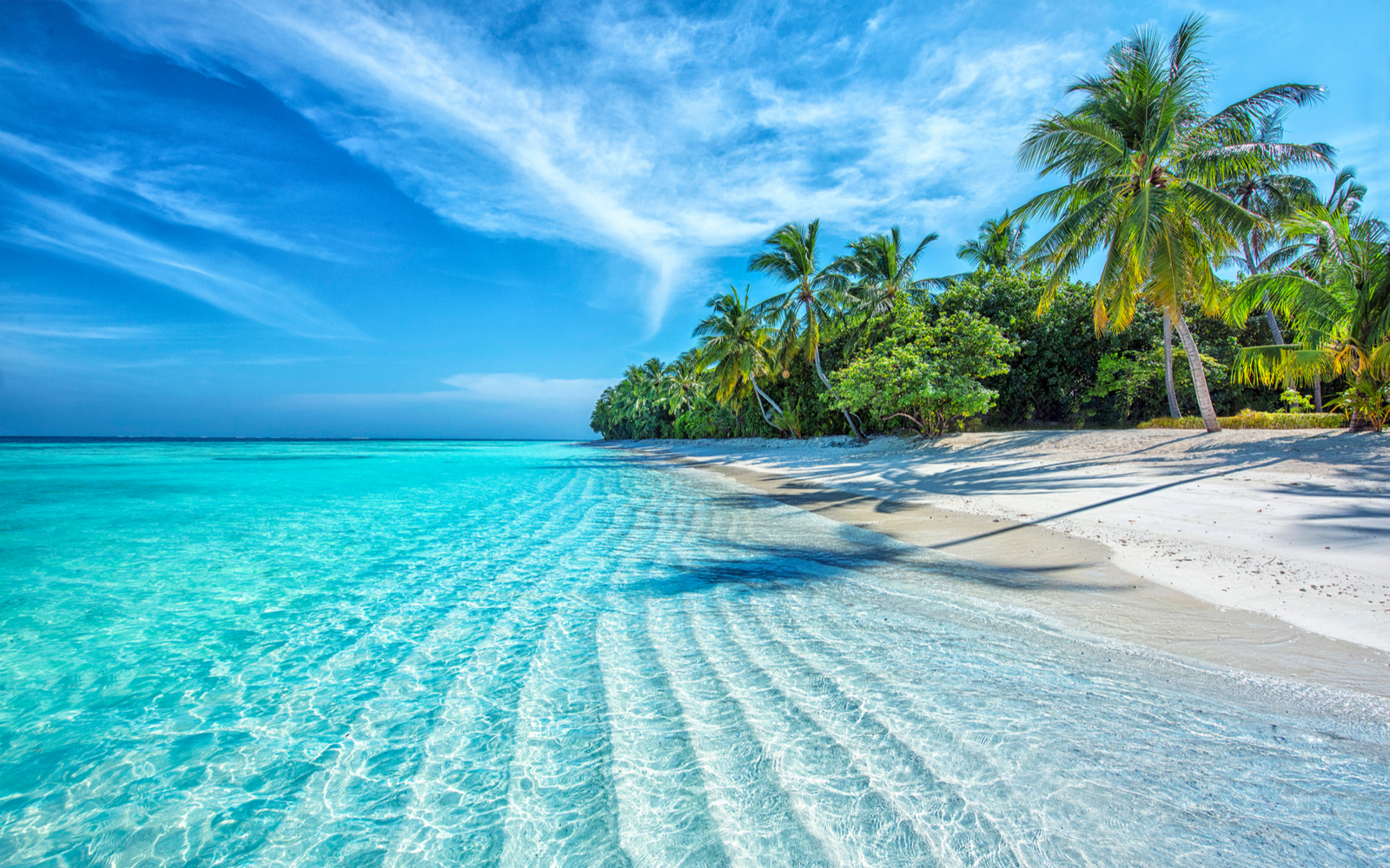 Gorgeous photo on a white sand beach with crystal-clear water for a piece on the safest islands in the Caribbean