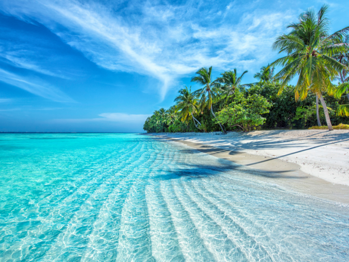 Gorgeous view of the Maldives, one of the best island vacations, pictured with rippling waves on the beach
