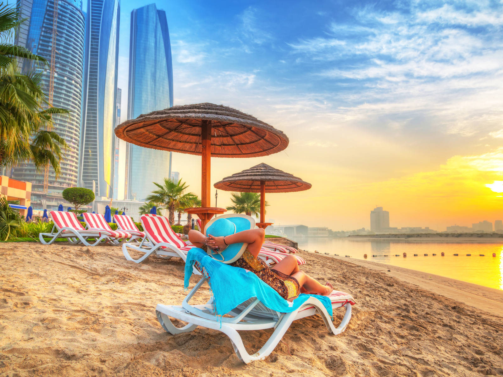 Image of a woman relaxing on the beach during the cheapest time to visit Dubai, mid-Summer