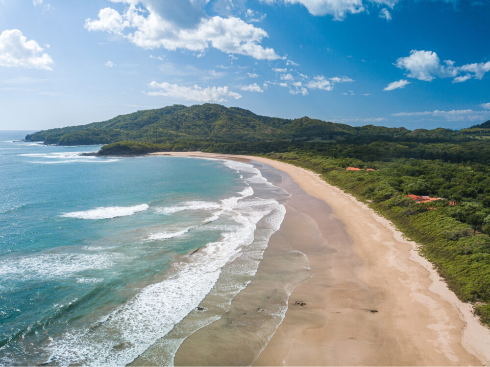 One of the best beaches in Costa Rica, Playa Grande's unique beach curved shoreline and fine sand captured on a partly cloudy day