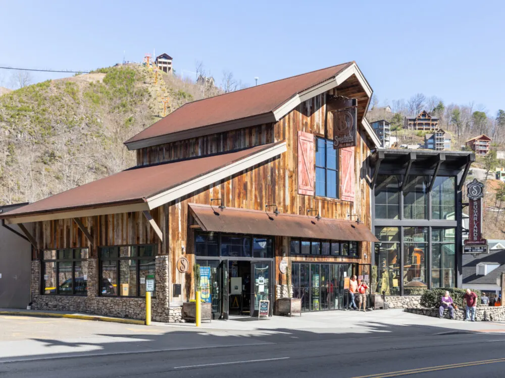 Open glass doors of Sugarlands Distilling Company, one of the best things to do in Tennessee, welcoming people during a bright clear day
