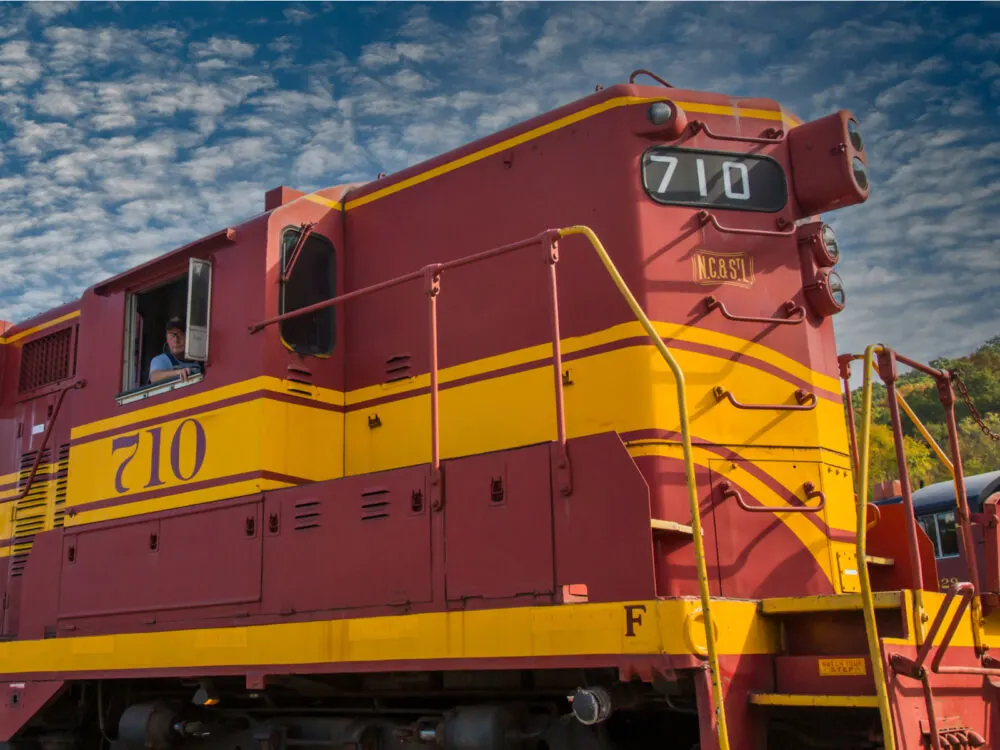 Operator seen by the window of an old train in Tennessee Valley Railroad Museum, pictured as a piece on one of the best things to do in Tennessee during a partly cloudy day
