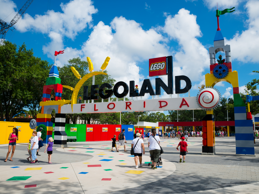 Families going inside Legoland Florida in Winter Haven, one of the best water parks in the USA, through its vibrant welcome arch 