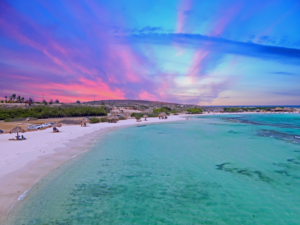 Breathtaking view of the pink and blue sky above the water of Baby Beach in Aruba, one of the safest islands in the Caribbean