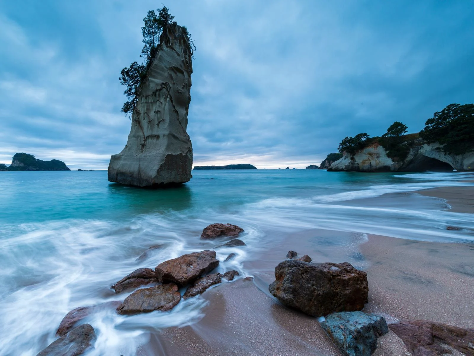 Te Whanganui, one of the best island vacations, pictured with a rock formation as seen from the coast