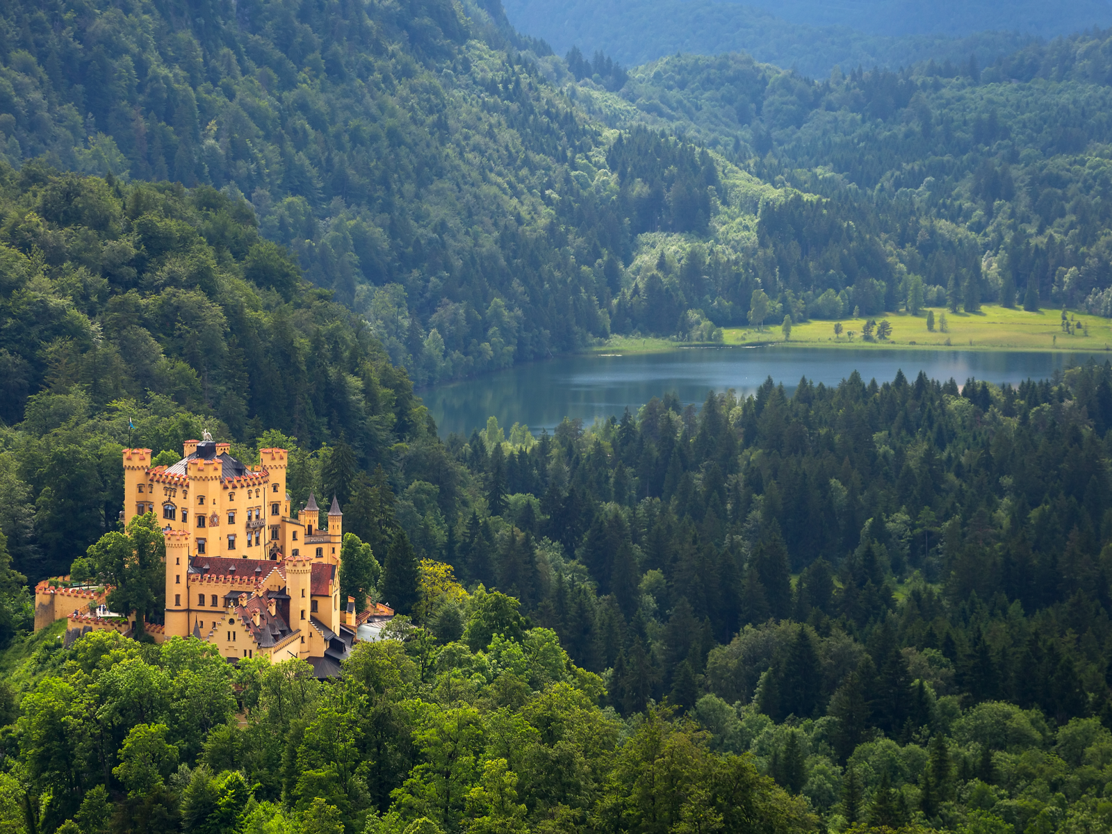 Situated in the of a dense forest in Balvarian Alps, one of the best castles in Germany, Hohenschwangau Castle's overlooking view of a calm river at a distance