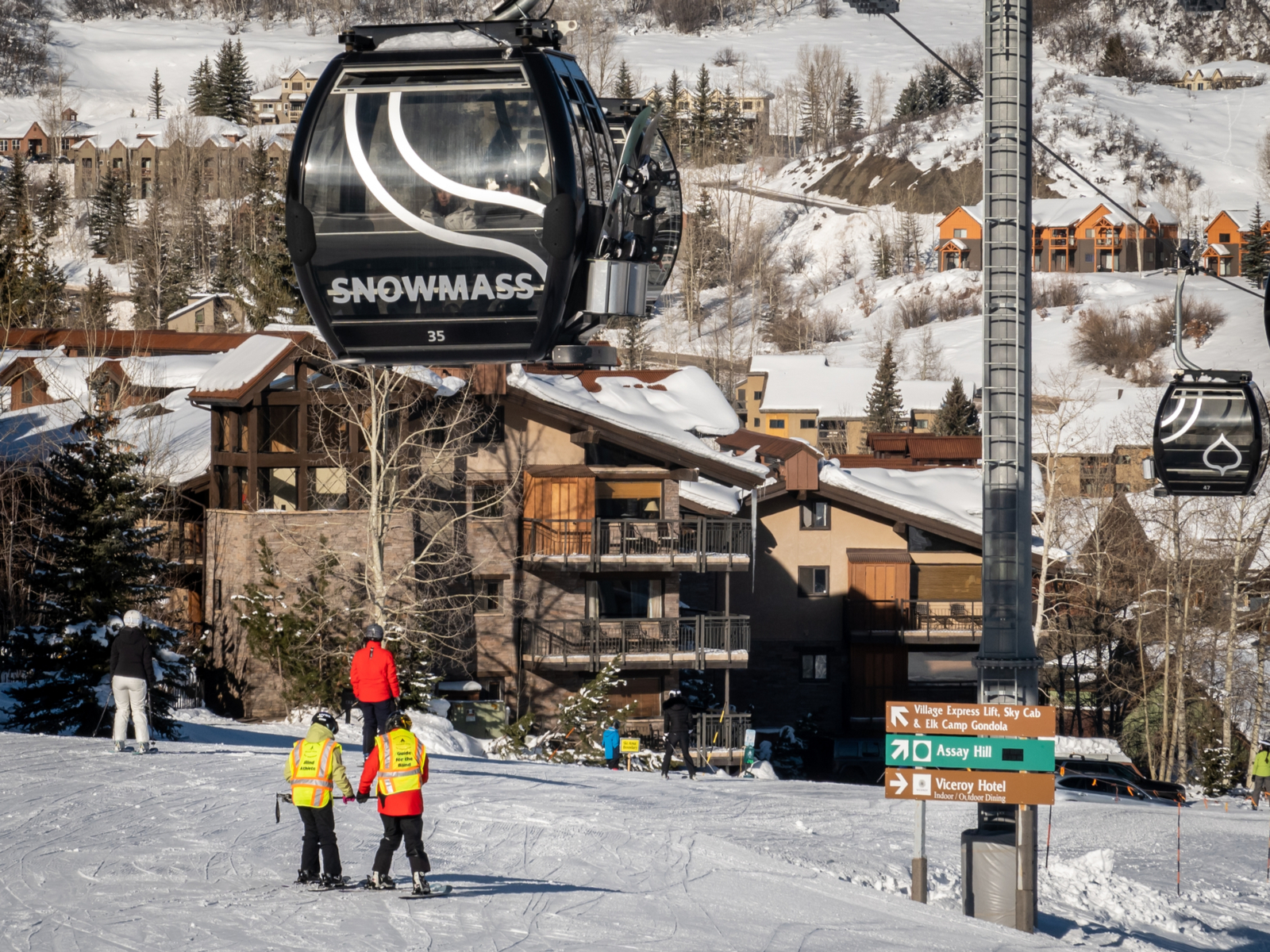 People in vests and skis at Snowmass, one of the best ski resorts near Denver