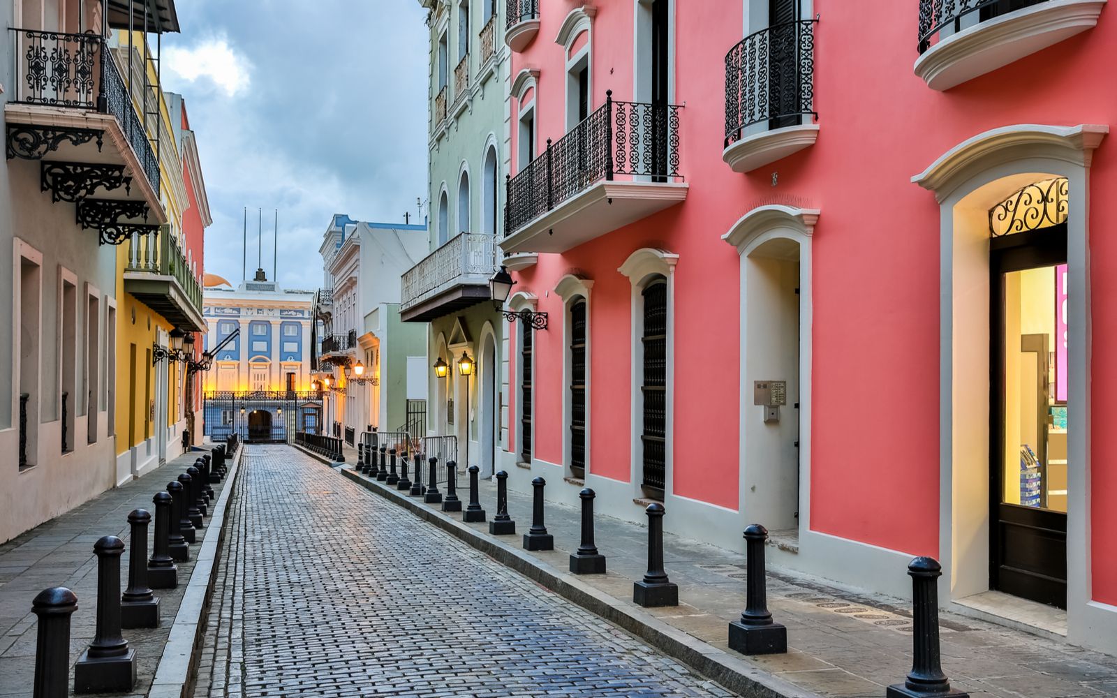Street in old San Juan with pink and yellow homes for a piece titled Best Things to Do in Puerto Rico