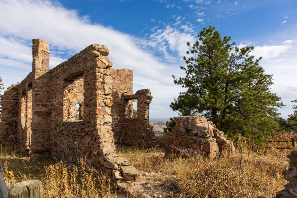 Ruins standing next to a tree in Mount Falcon Castle Trail, one of the best hikes near Denver