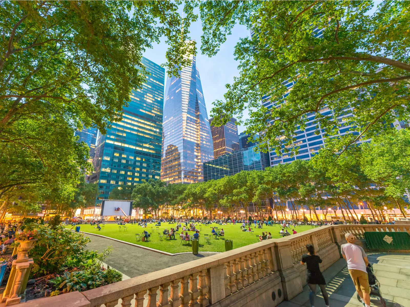 Bryant Park, one of the top things to do in New York City, pictured from the walkway with a stone railing in the foreground