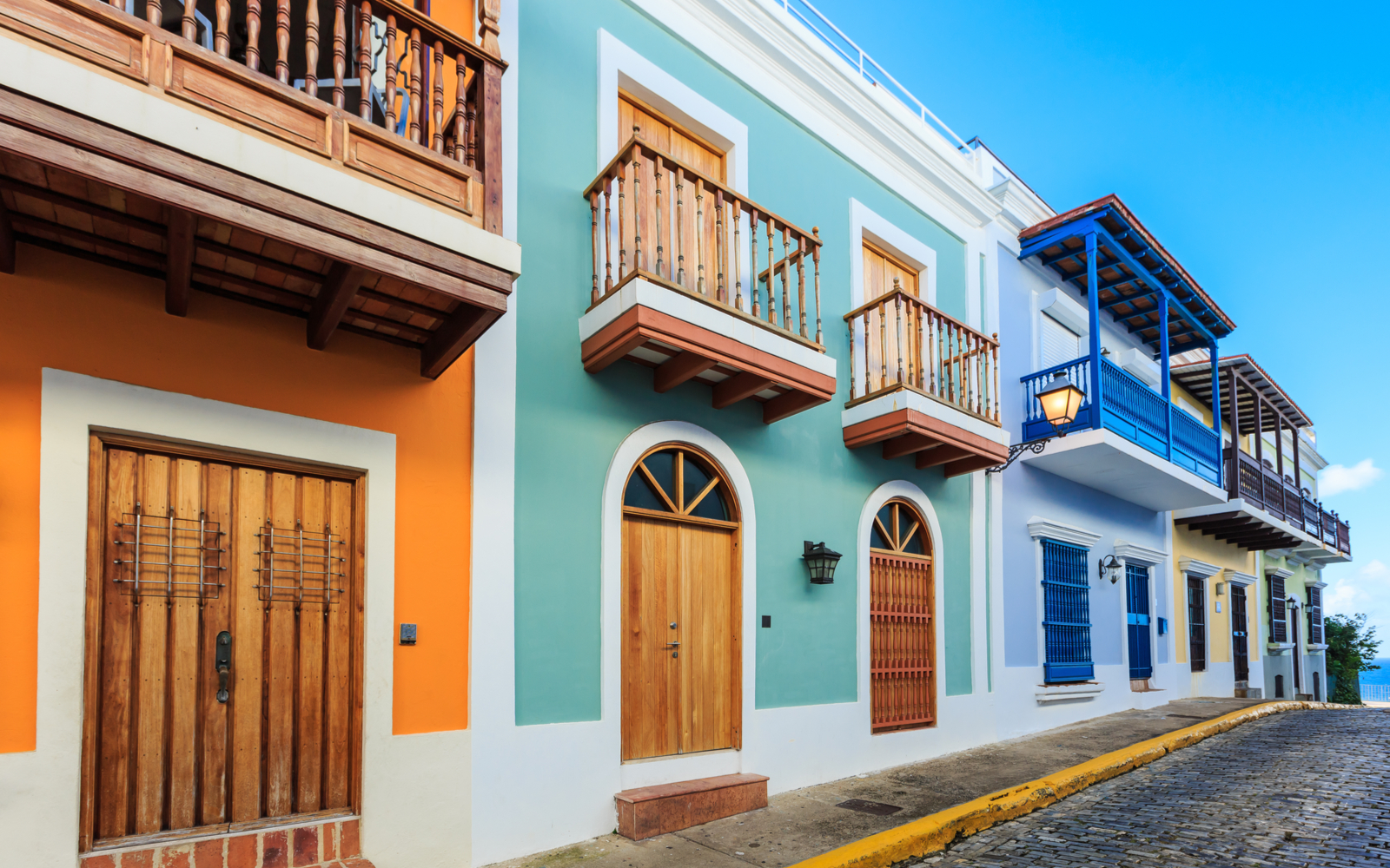A bunch of bright colored houses on a street for a piece on the best hotels in Puerto Rico