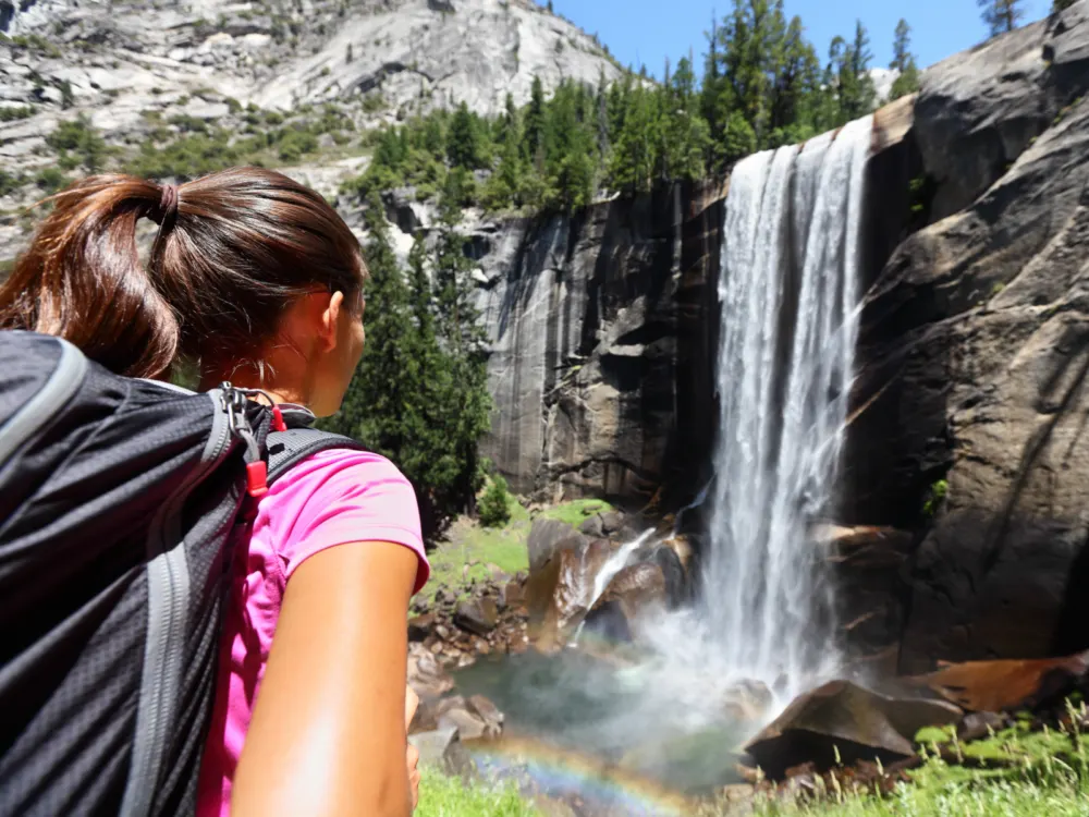 Young backpacker looking at the Vernal Falls for a piece on the cheapest time to visit Yosemite