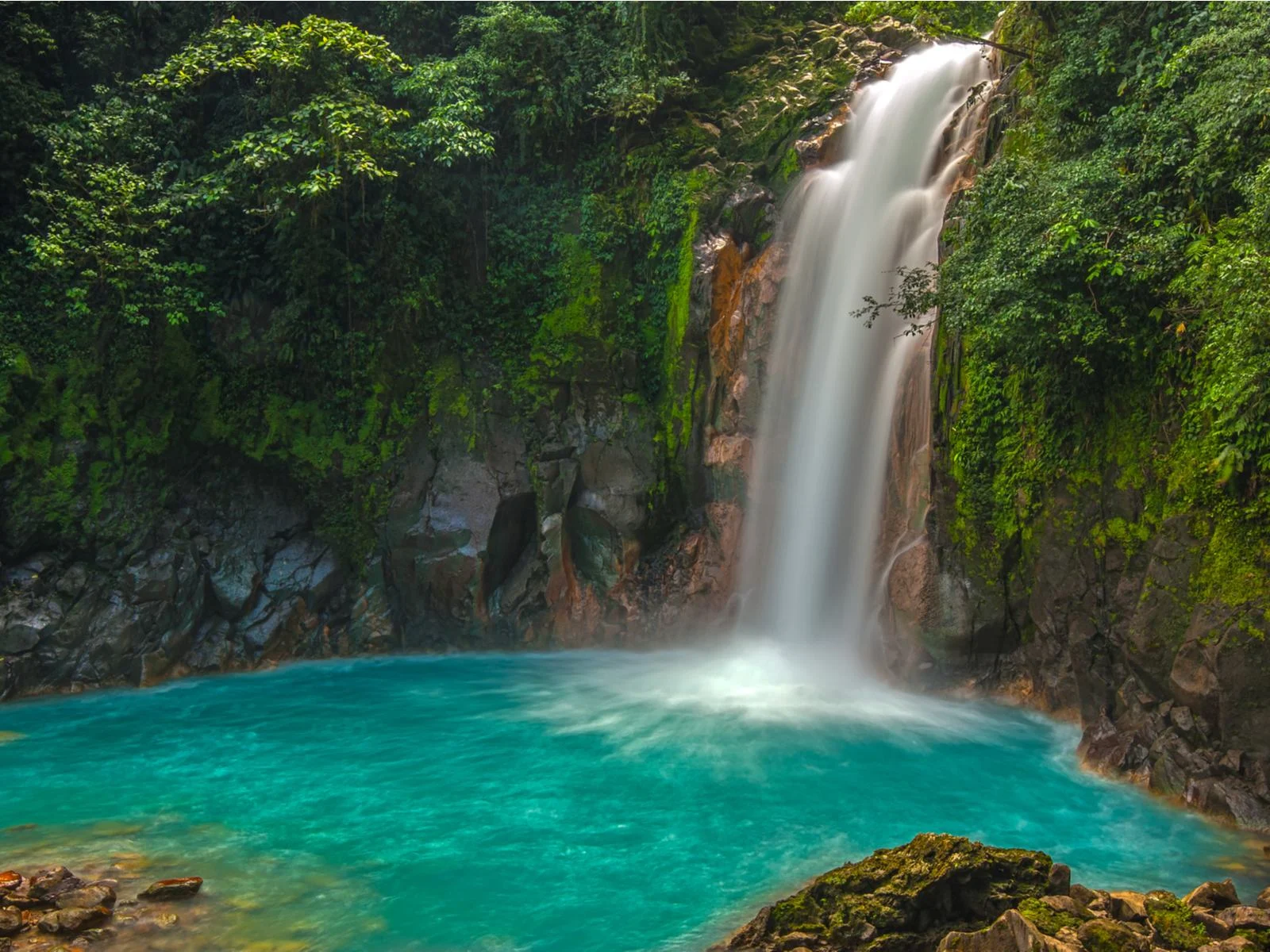 Surreal Rio Celeste Waterfall, one of the best things to do in Costa Rica, with pristine greeneries and moss-covered rocks