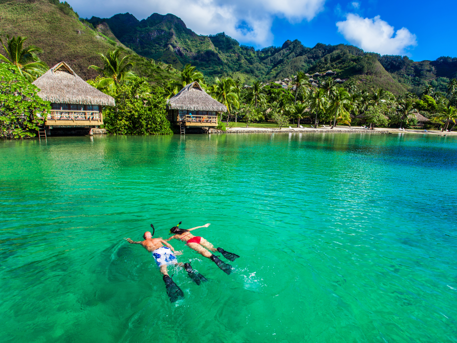 Couple snorkeling over a green lagoon for a piece on the best time to visit Bora Bora