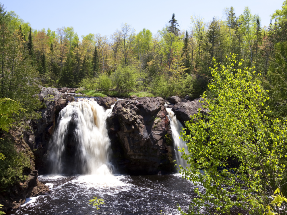 The Little Manitou Falls surrounded by trees on Spring at Pattison State Park, one of the best Wisconsin tourist attractions