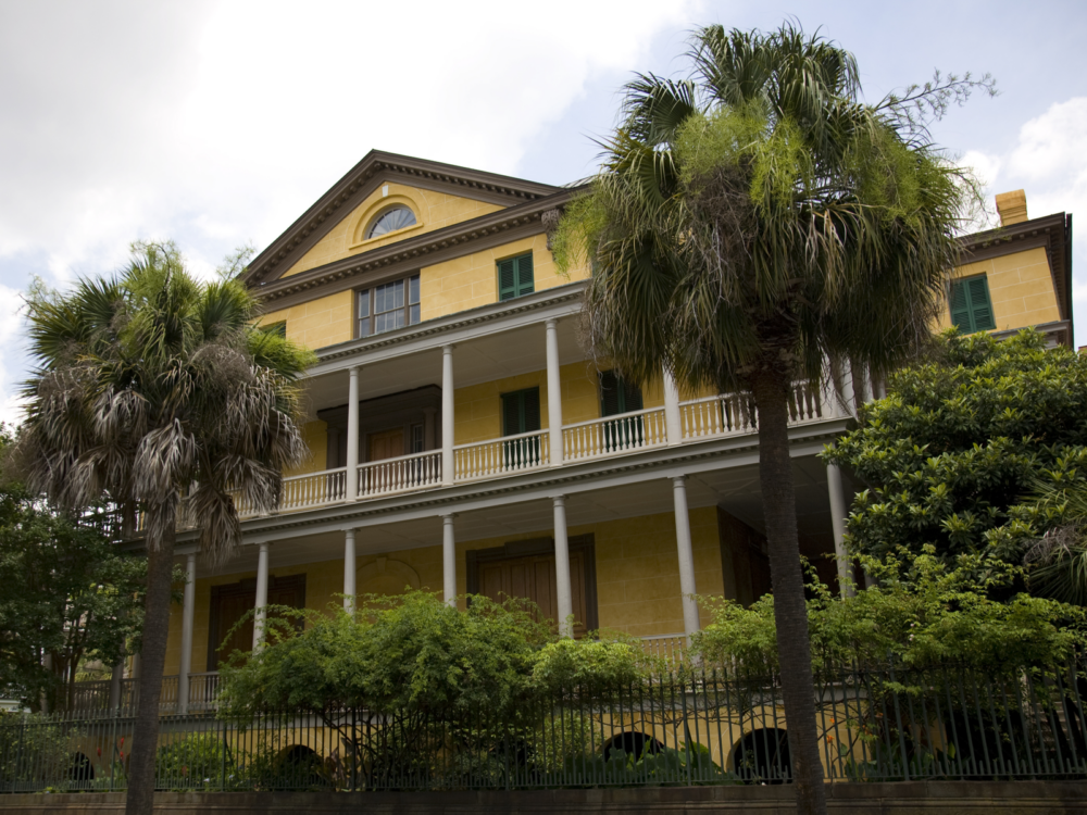 Listed on the National Register of Historic Places and one of the best South Carolina attractions, the Aiken-Rhett House painted yellow and fenced
