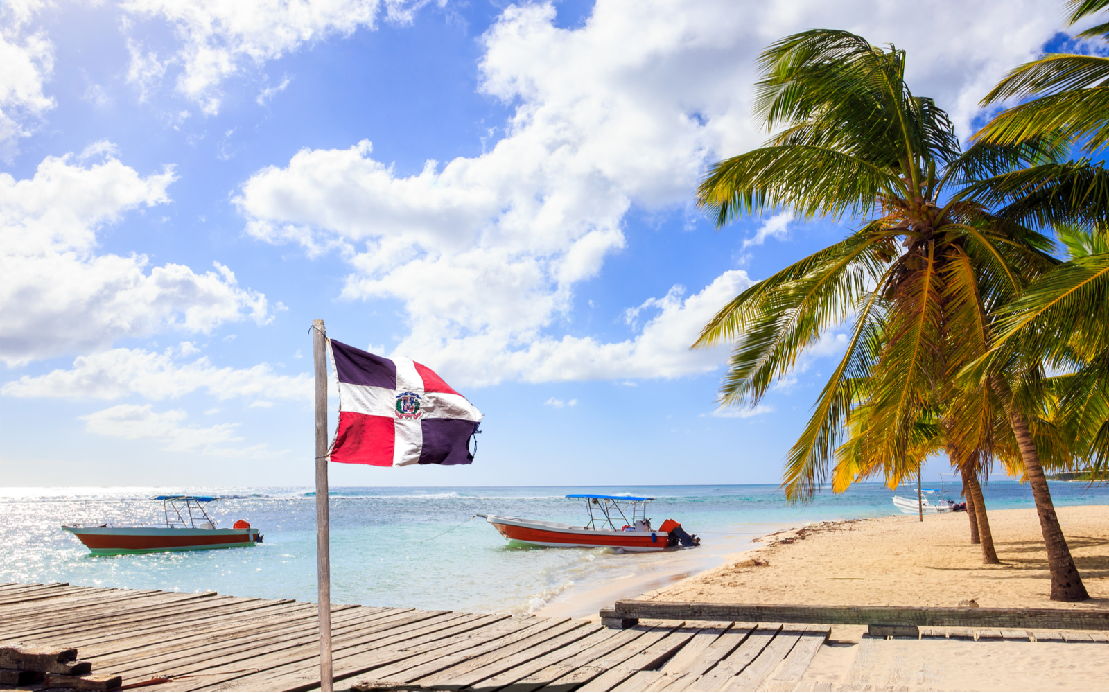 As a featured image for a piece on the best resorts in the Dominican Republic, Caribbean beach and Dominican Republic flag on Saona island