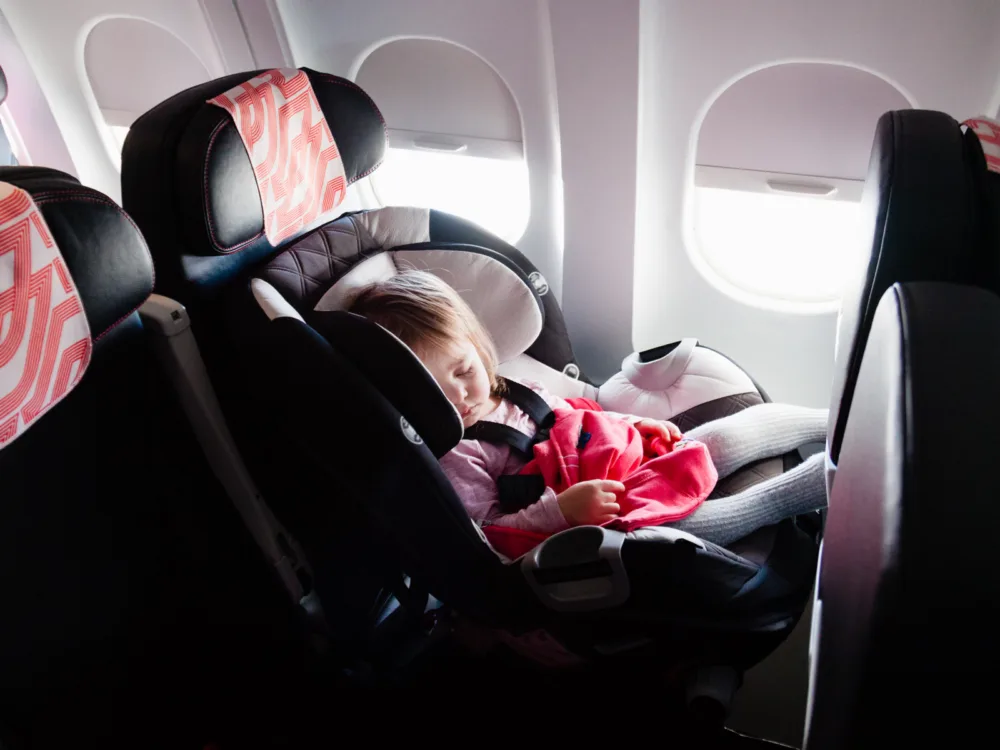 Image of a baby in the best travel car seats next to a window