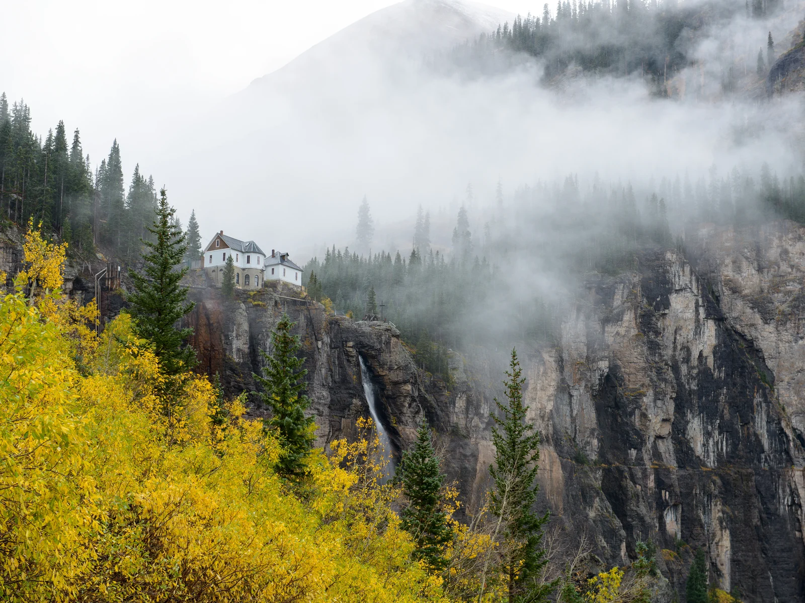 A lonely house on misty peaks of Bridal Veil Falls, as seen from Black Bear Pass trail in Deer Creek Canyon Park, one of the best hikes near Denver