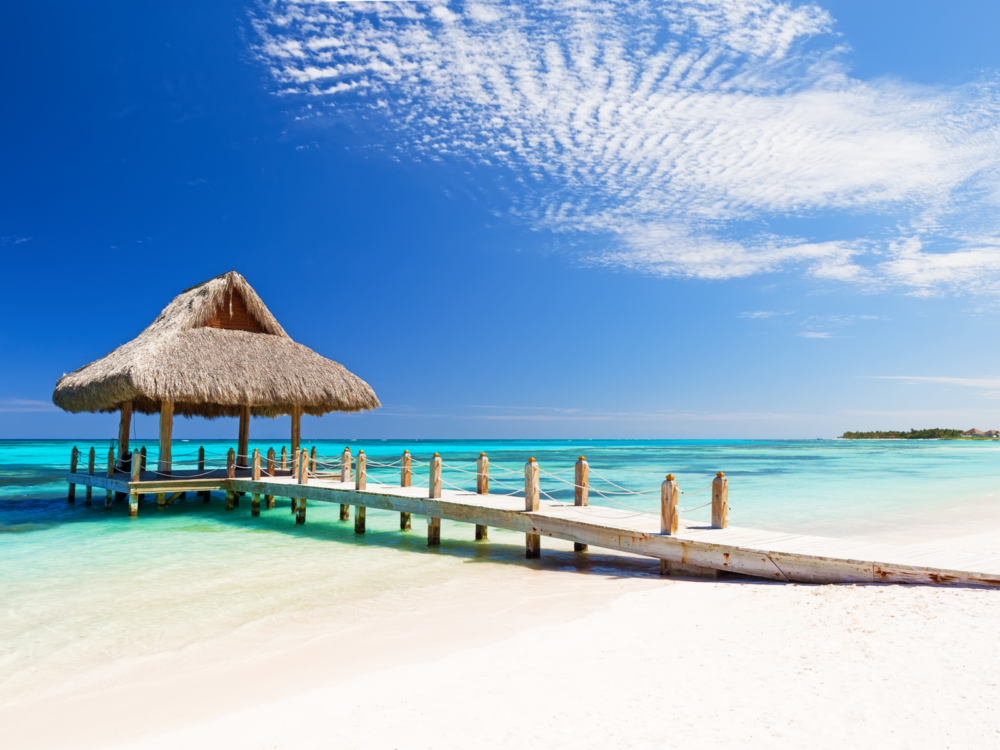 Gorgeous white tropical beach above teal water for a piece on the best resorts in the Dominican Republic