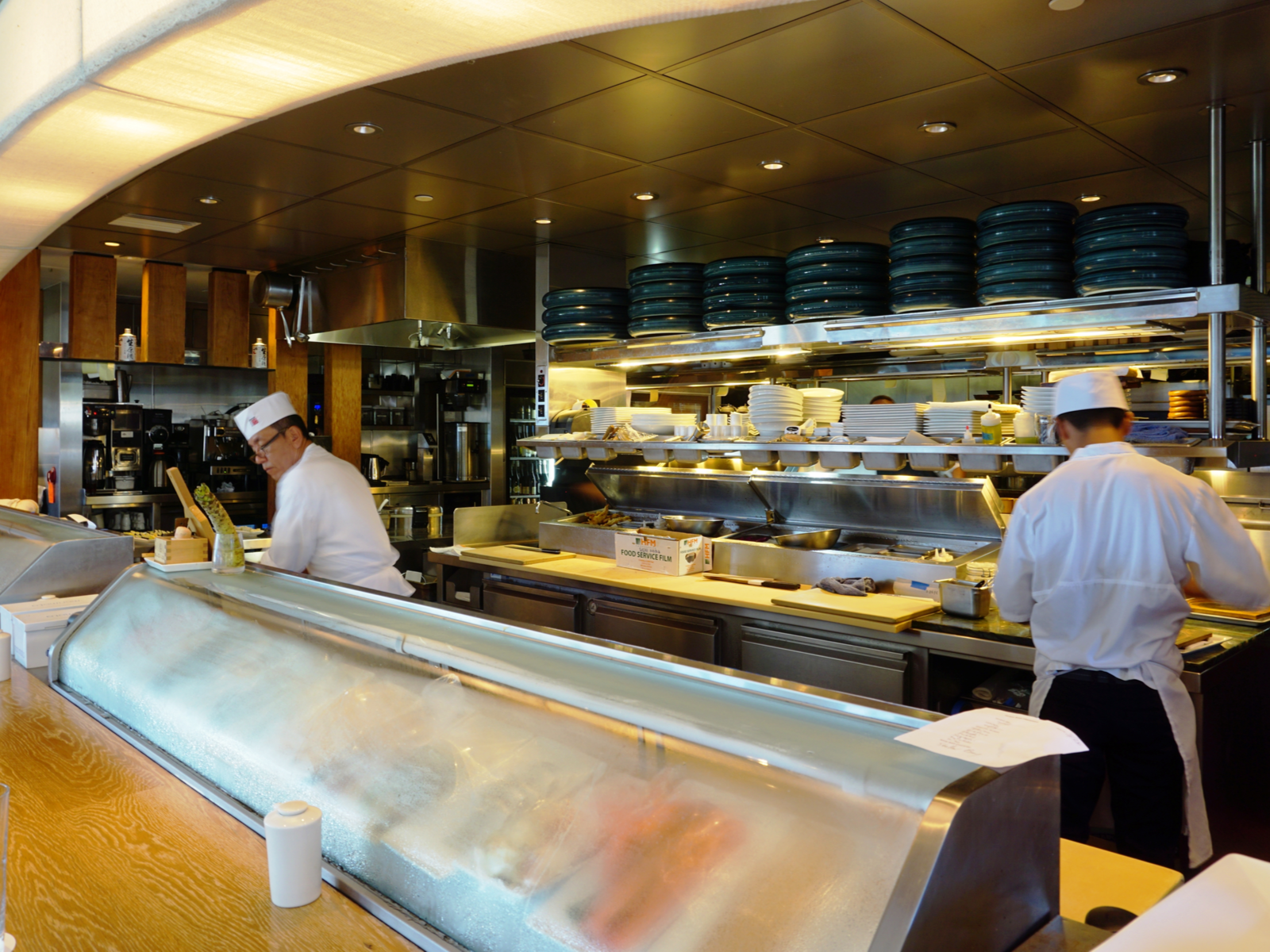 Two chefs preparing to serve a dish in the kitchen of Masaharu Morimoto, one of the best restaurants in Maui, Hawaii