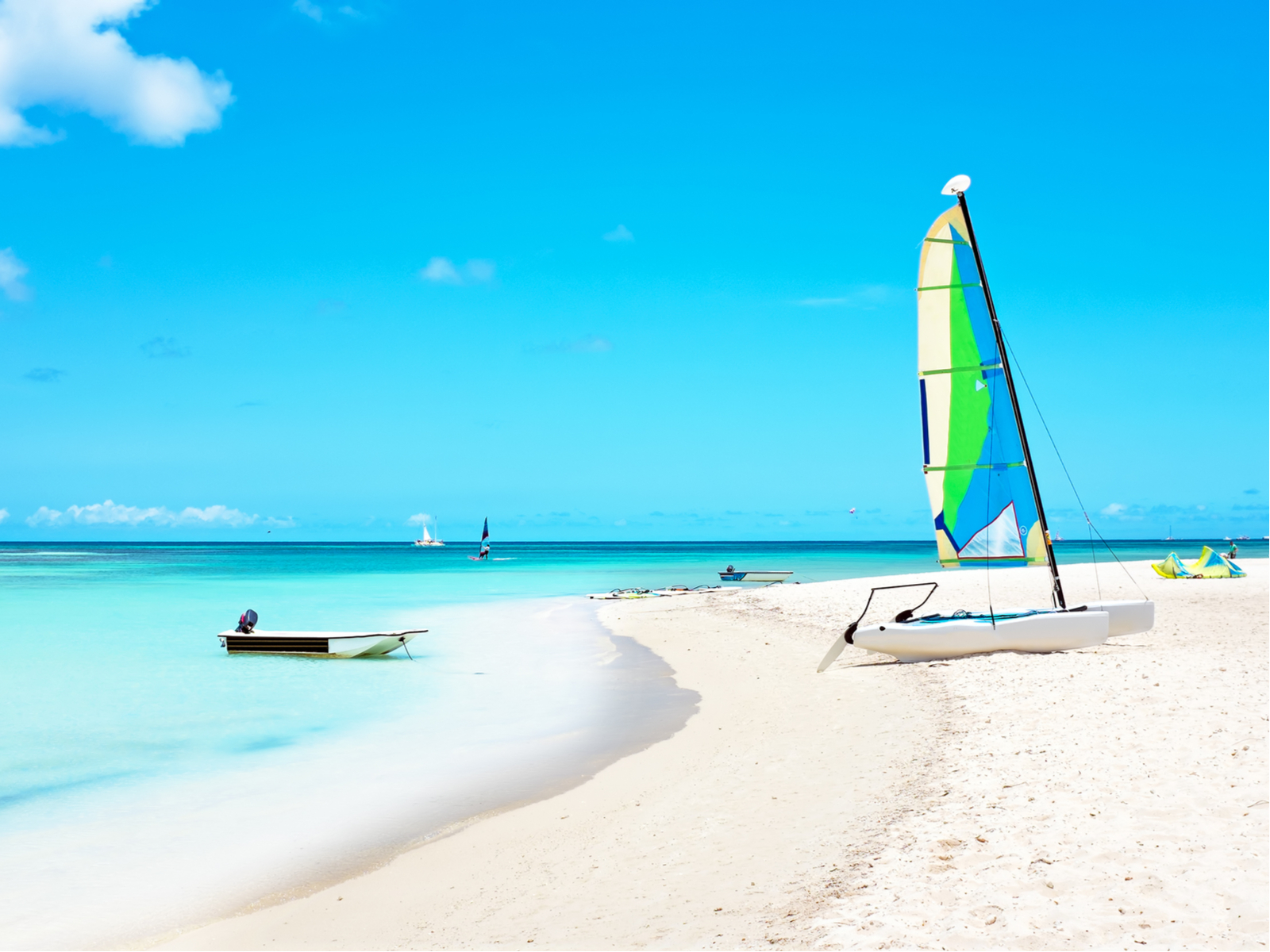 Fisherman's hut with a pontoon sailboat shown on one of the best beaches in Aruba