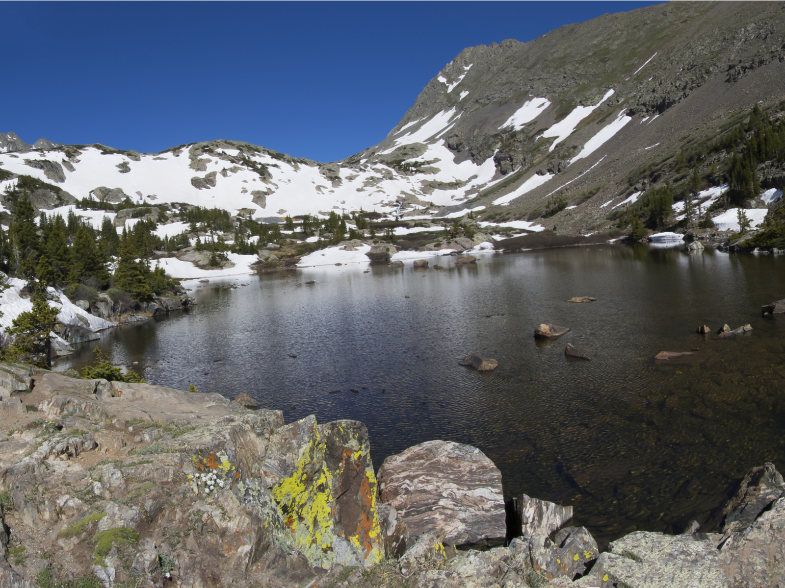 The cold waters of Mohawk Lake, surrounded by icy slopes, is a popular hiking trail and one of the best hikes near Denver