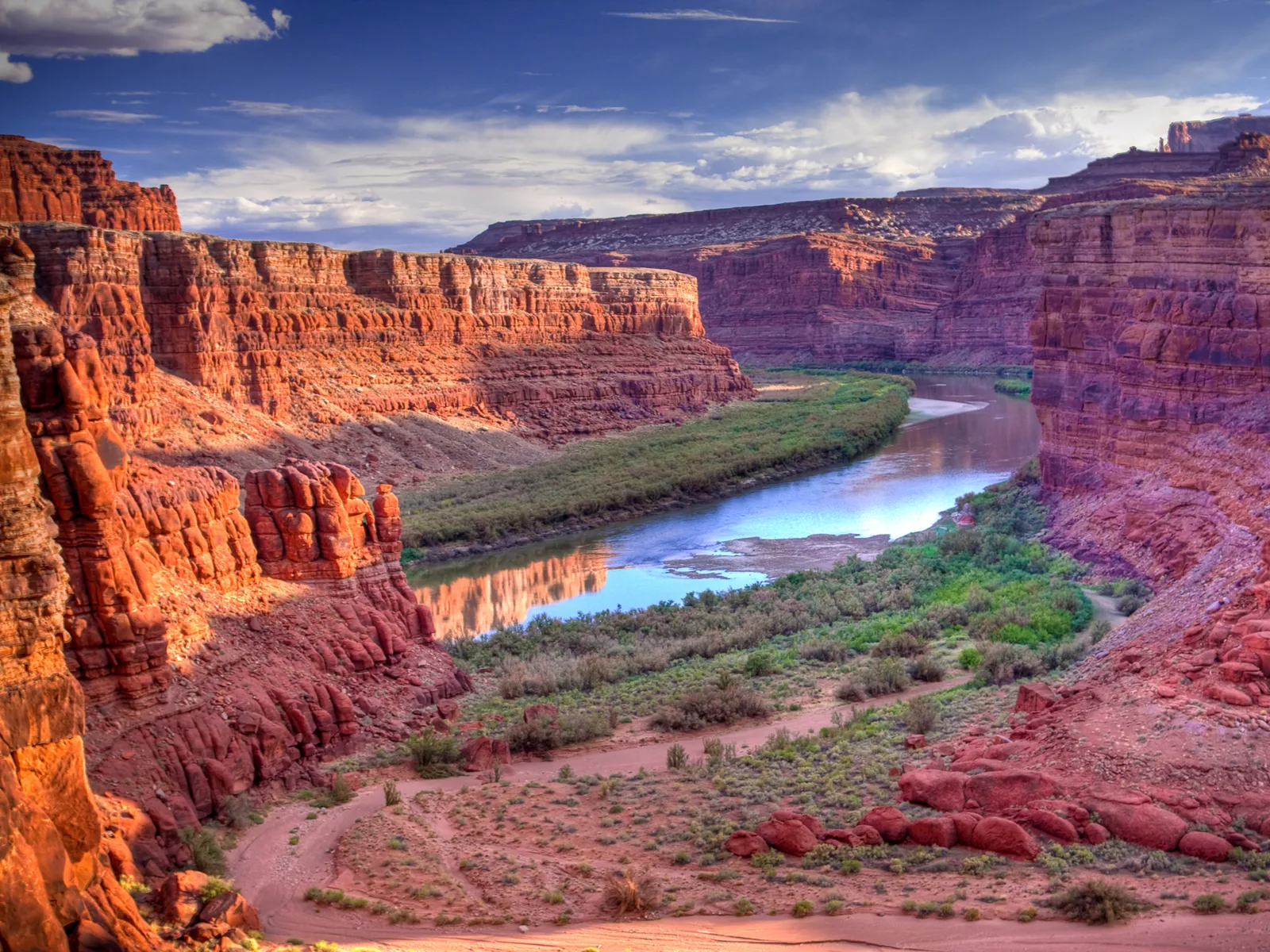 Colorado River running through a canyon in Canyonlands National Park, one of Utah's best places to visit, seen at dusk with red rocks