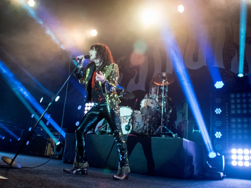 The Struts passionately performing in a concert at The Fillmore, one of the best places to visit in San Francisco, where bright show lights flash from the stage