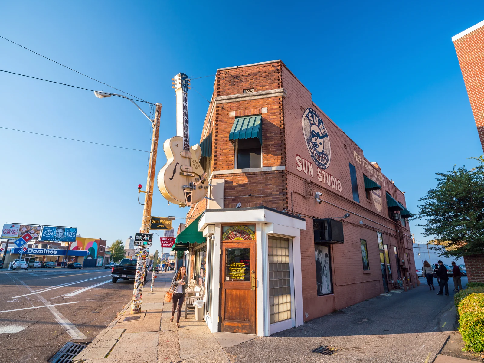 A photo of Sun Studio, titled as "The Birthplace of Rock'n'roll" with its giant guitar hanging above the entrance, alongside an empty street as a piece on the best things to do in Tennessee