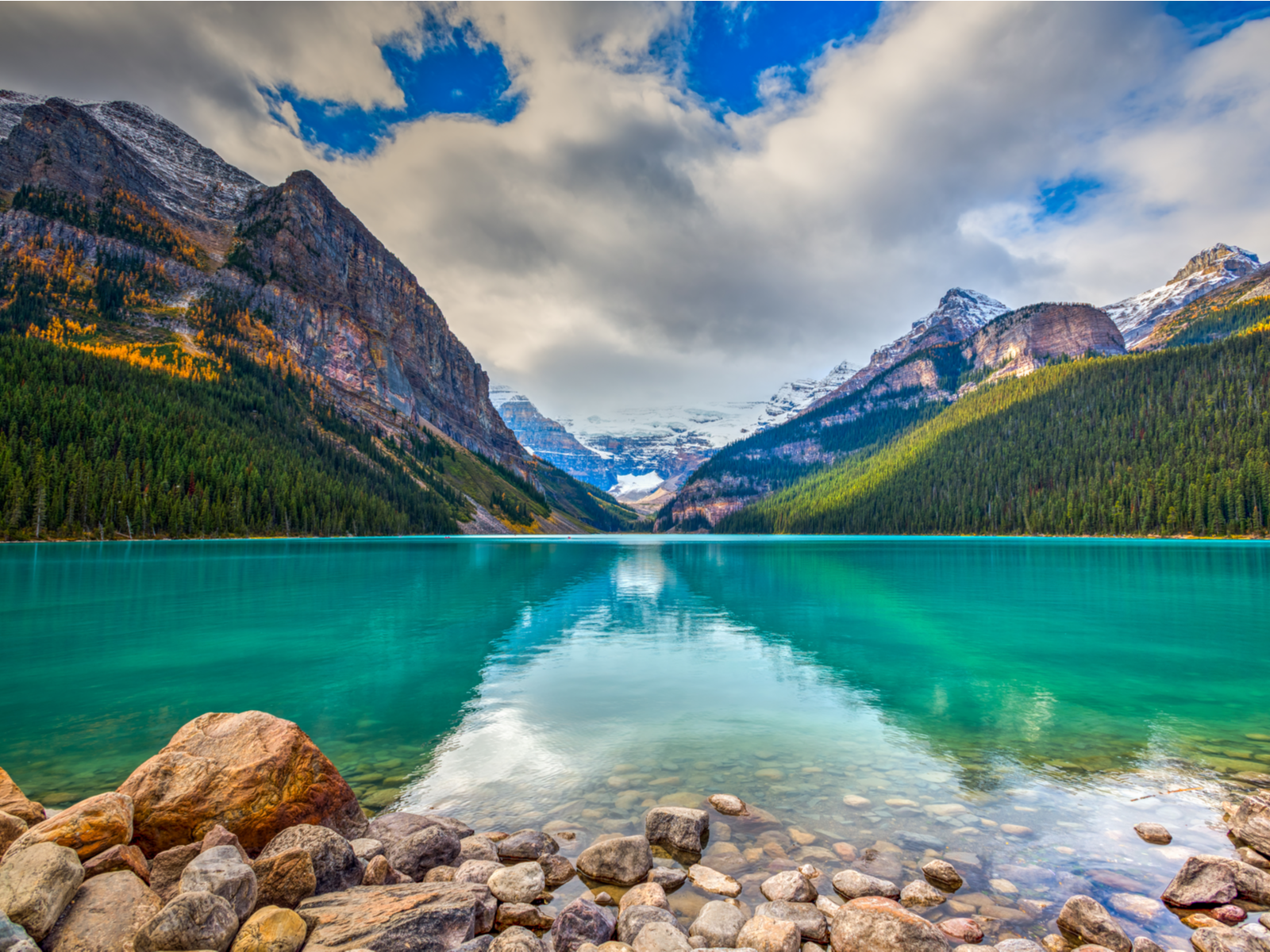 Clear water of the rocky Lake Louise, one of the best places to visit in Canada, surrounded Rocky Mountains on an Autumn view