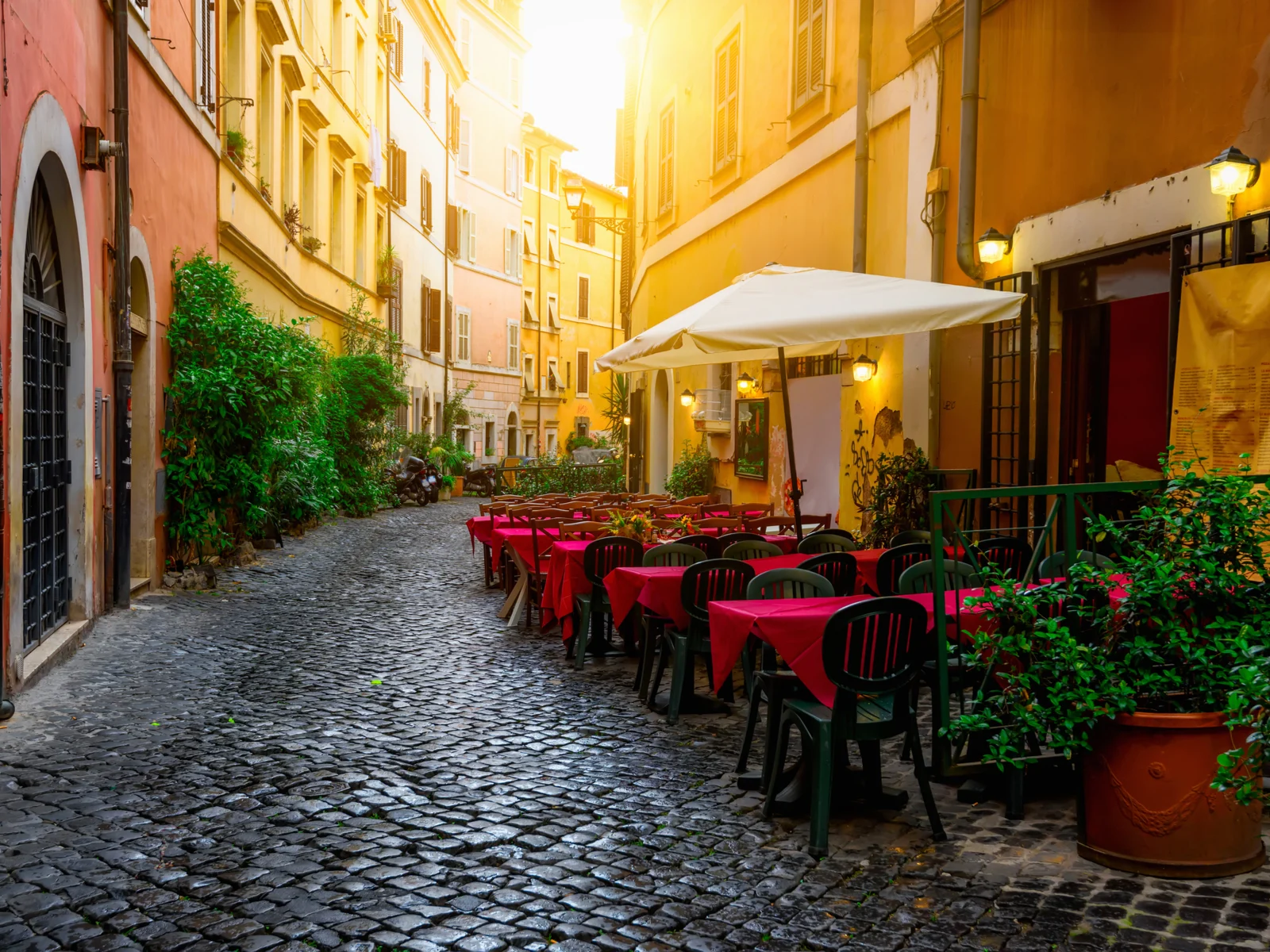 Cozy coffee shop pictured during the least busy time to visit Italy while the sun sets on the town square
